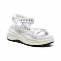 White leather platform sandals with studded straps and ankle wrap.