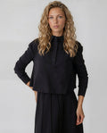 Long sleeve black jersey half button cropped collar shirt with pockets.