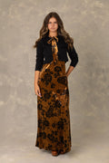 Copper print velvet maxi dress with neck tie bow and matching black knit cardigan.