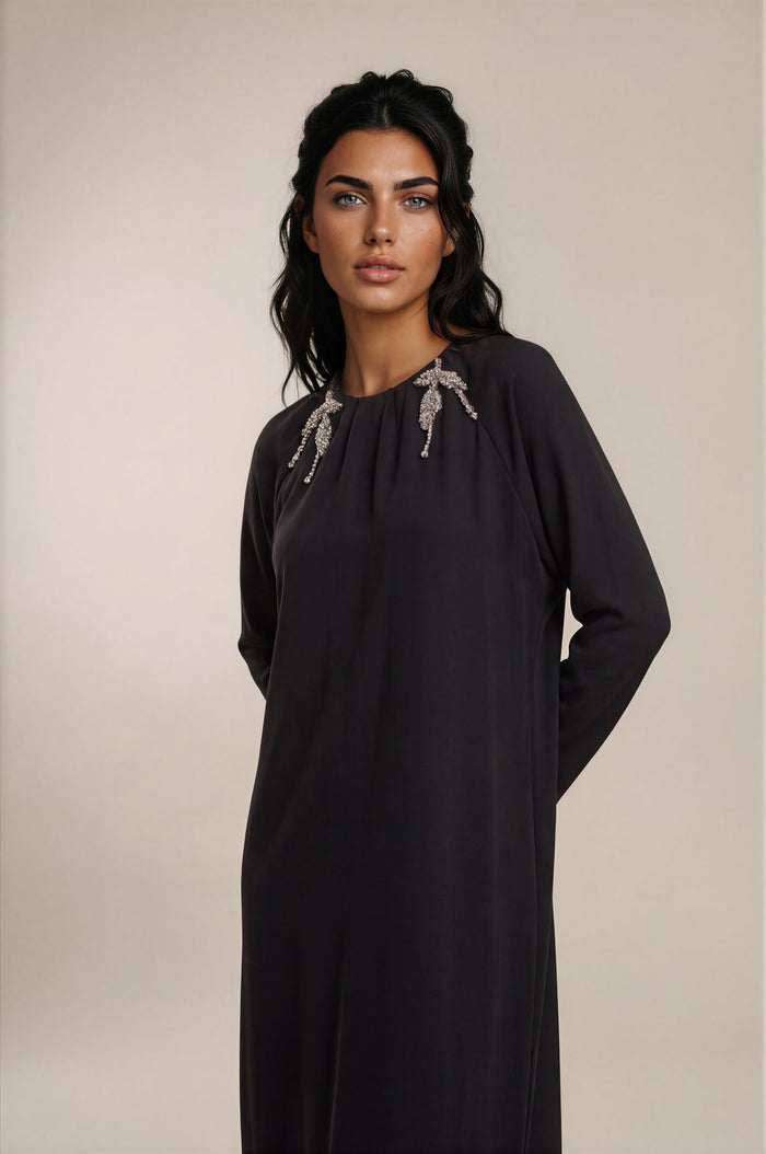 Black long sleeve maxi dress with crystal leaf applique.