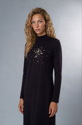 Black jersey long sleeve maxi dress with mock turtleneck collar and rhinestone sunburst applique.