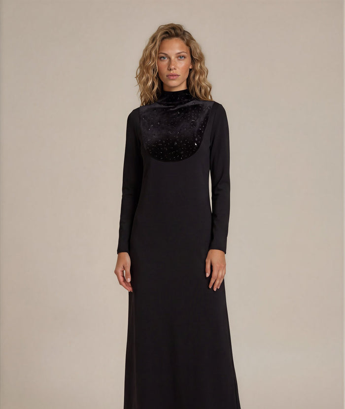 Black long sleeve jersey maxi dress with rhinestone studded velvet bib and mock turtleneck collar.