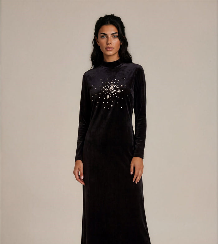 Black velvet long sleeve maxi dress with mock turtleneck collar and rhinestone sunburst applique.