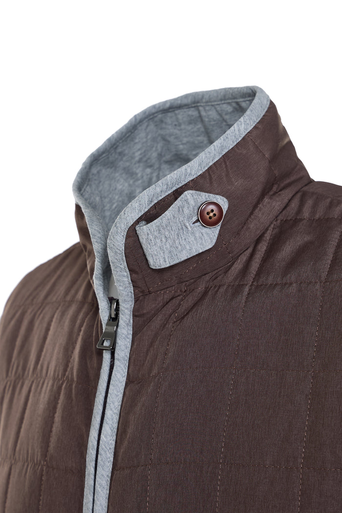 Close-up of a brown jacket with gray collar and button on a white background