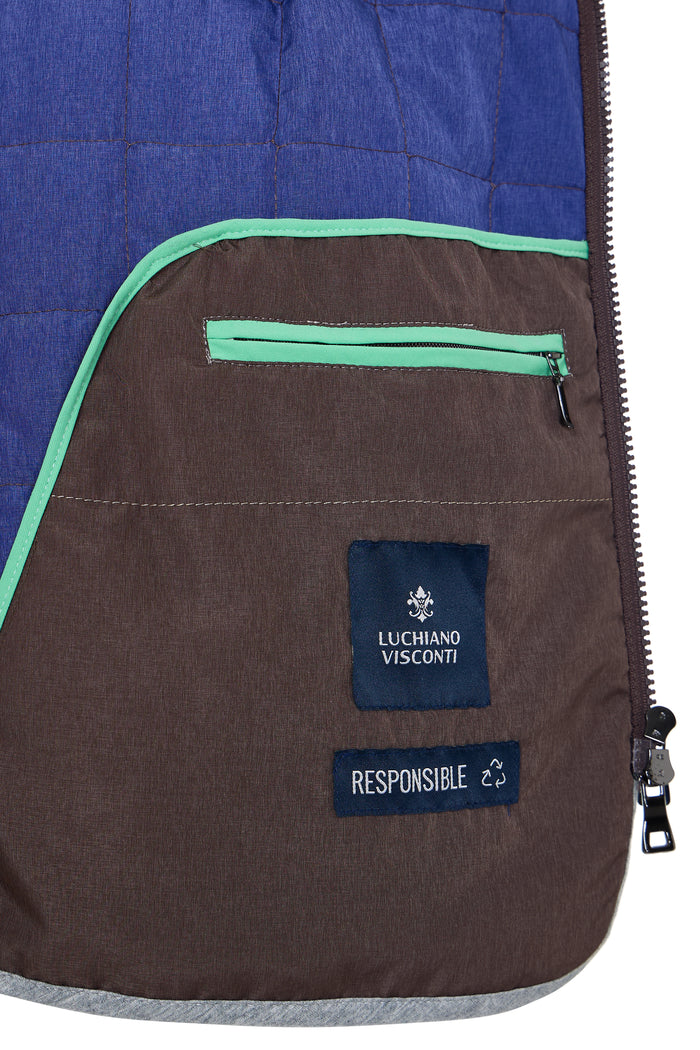 Close-up of a brown and blue jacket with a visible brand label on a white background