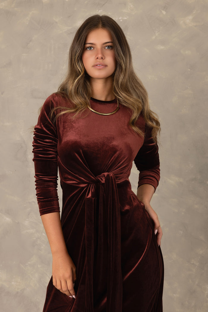 Burgundy velvet long sleeve maxi dress with front knot detail.