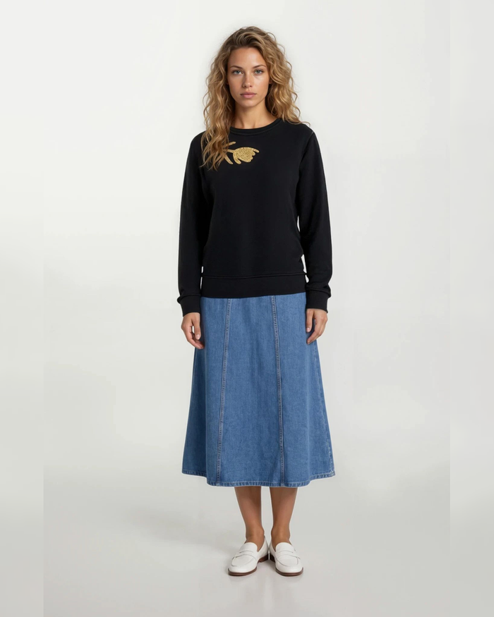 Black long-sleeve top with gold chest embroidery, crew neckline