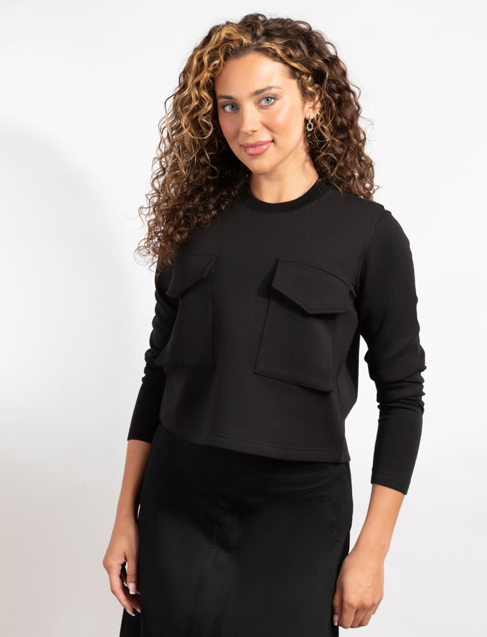 Cropped black long-sleeve top with two front flap pockets, relaxed fit