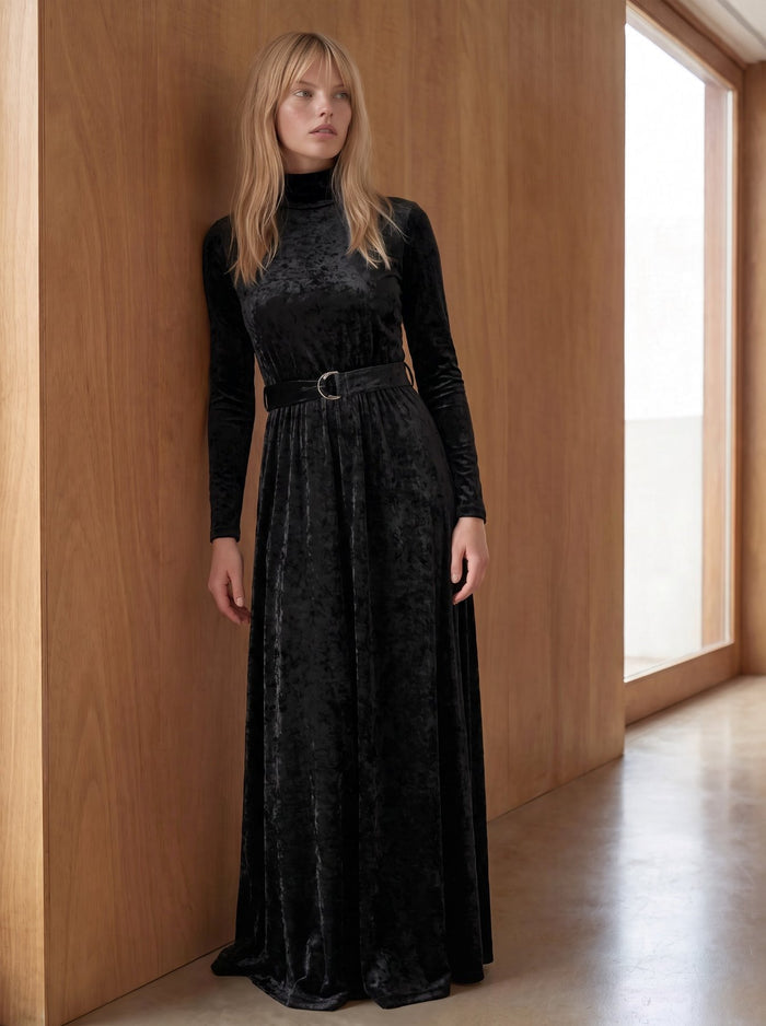 Black crushed velvet long sleeve maxi dress with mock turtle neck collar and metal loop self belt.