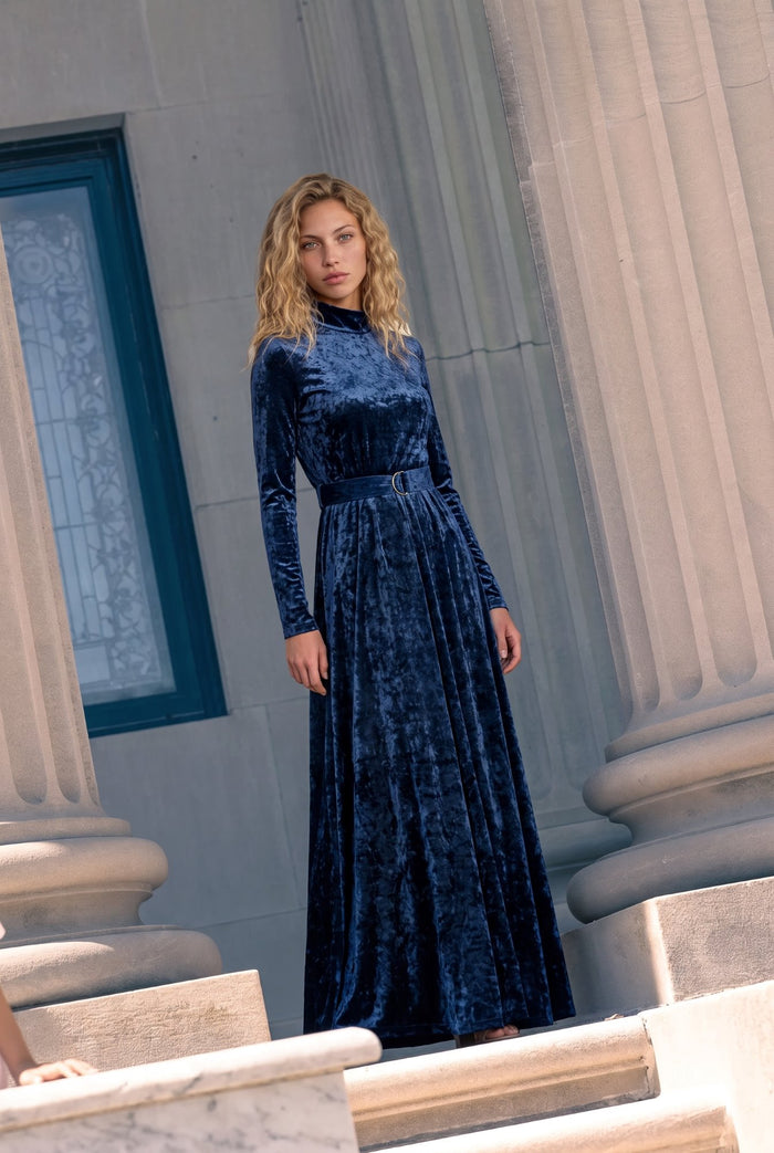 Navy crushed velvet long sleeve maxi dress with mock turtle neck collar and metal loop self belt.