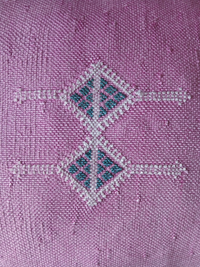 Pair of beaded earrings on a textured purple fabric background