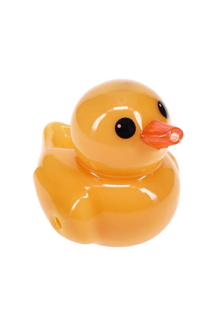 Angled view of yellow ducky-shaped glass hand pipe showing sculpted duck face and smooth glossy finish for dry herb