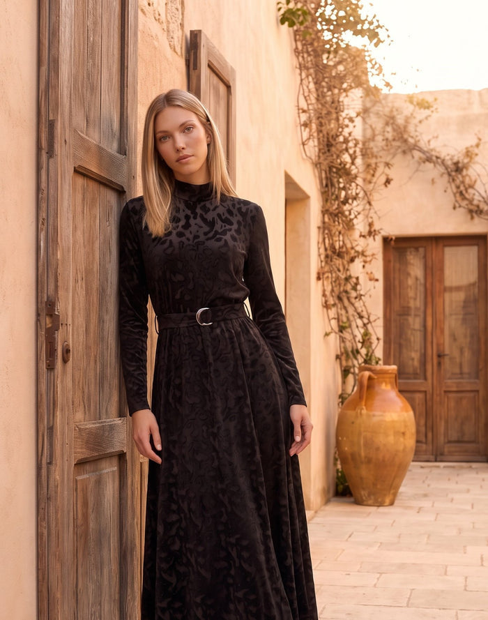 Black patterned velvet long sleeve maxi dress with mock turtle neck collar and metal loop self belt.