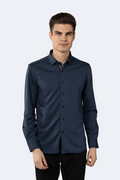 A man wearing a navy and black long-sleeved circular jacquard shirt