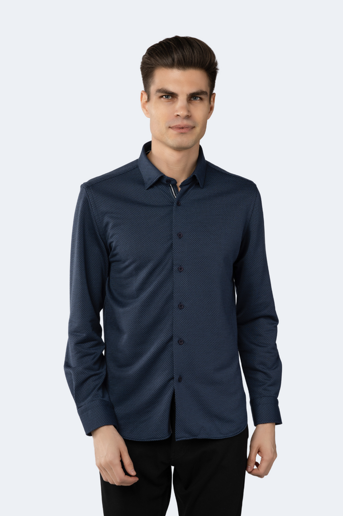 A man wearing a navy and black long-sleeved circular jacquard shirt
