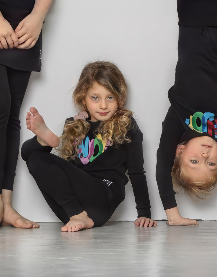 Kids black long-sleeve pajama top and leggings set with colorful heart Enjoy print