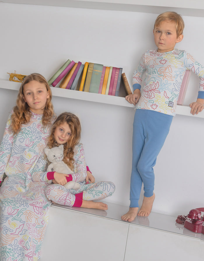 Kids wearing leaf-pattern long-sleeve pajamas with solid blue leggings