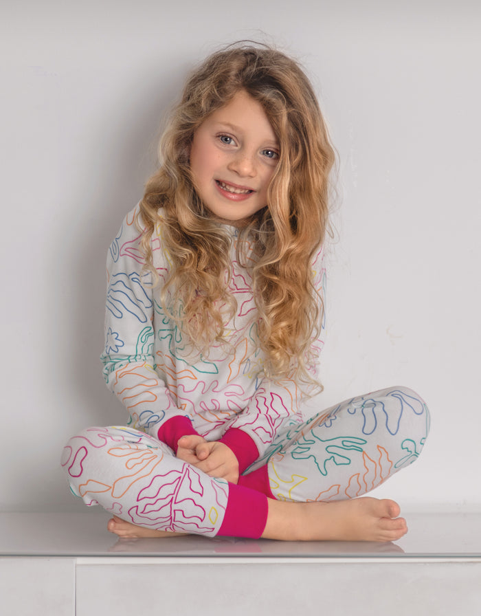 Kids pajama set worn by child, colorful line print with hot pink cuffs and matching leggings