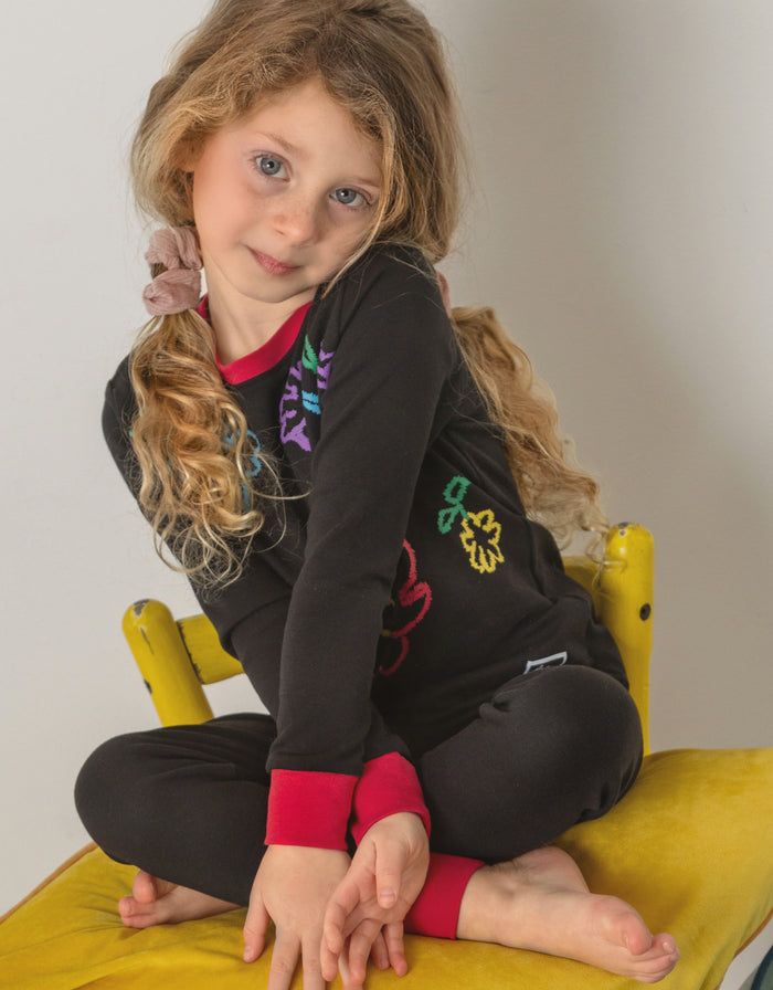 Kids black pajama set with multicolor fuzzy flowers on long sleeves and leggings, red cuffs