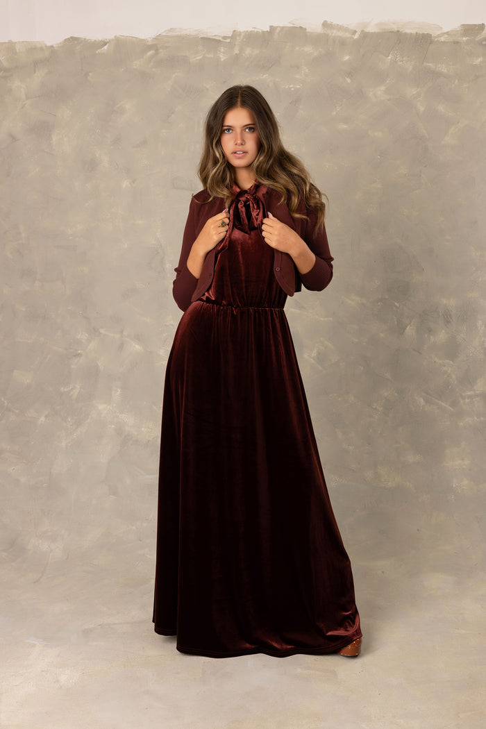 Burgundy velvet maxi dress with neck tie bow and matching knit cardigan.