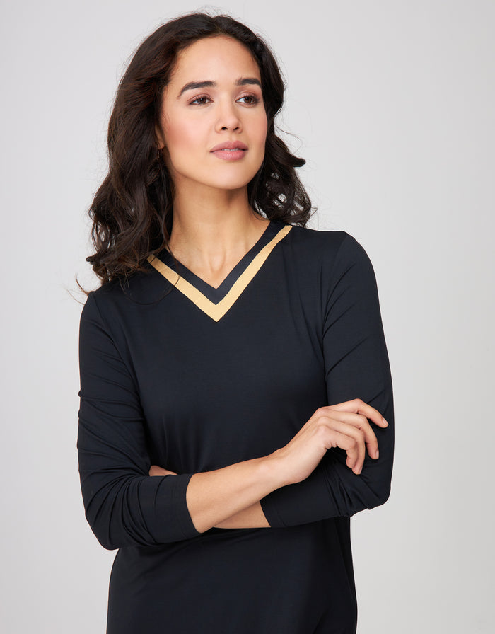 Black nightgown with gold satin-trim V-neck and long sleeves, close-up.