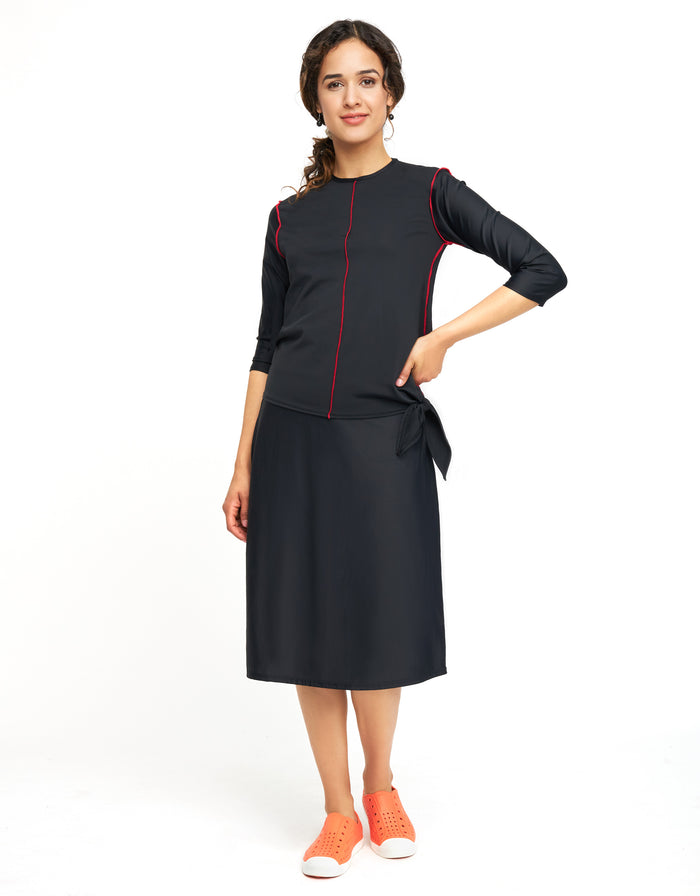 Black swim skirt with attached shorts and red piping, knee-length