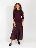 Two-piece maroon fitted sweater and flowing midi skirt set with long sleeves