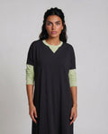 Black pull on nightgown with contrasting  light green long sleeves and neck trim.
