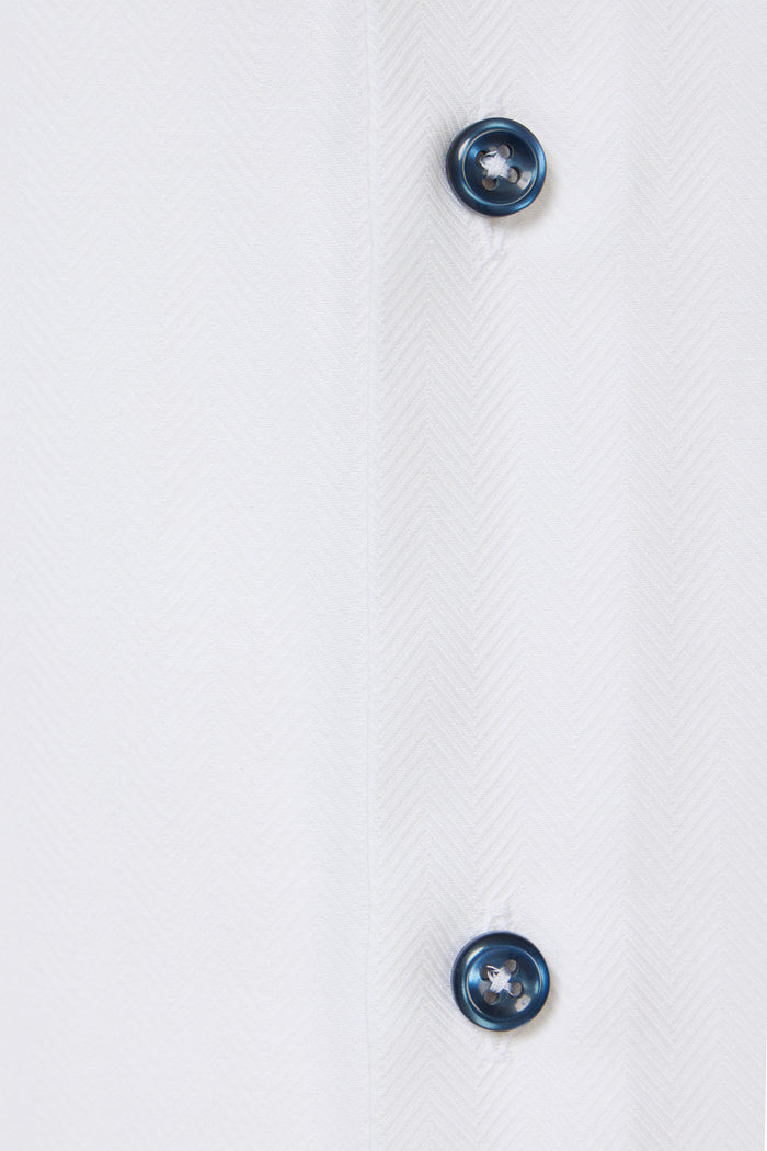 Two blue buttons on a white fabric background