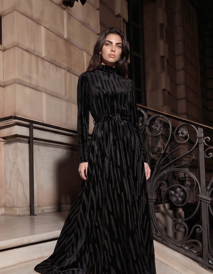 Black patterned velvet long sleeve maxi dress with mock turtle neck collar and metal loop self belt.