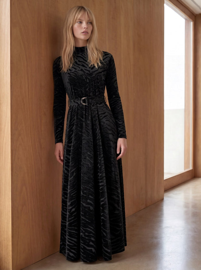 Black patterned velvet long sleeve maxi dress with mock turtle neck collar and metal loop self belt.