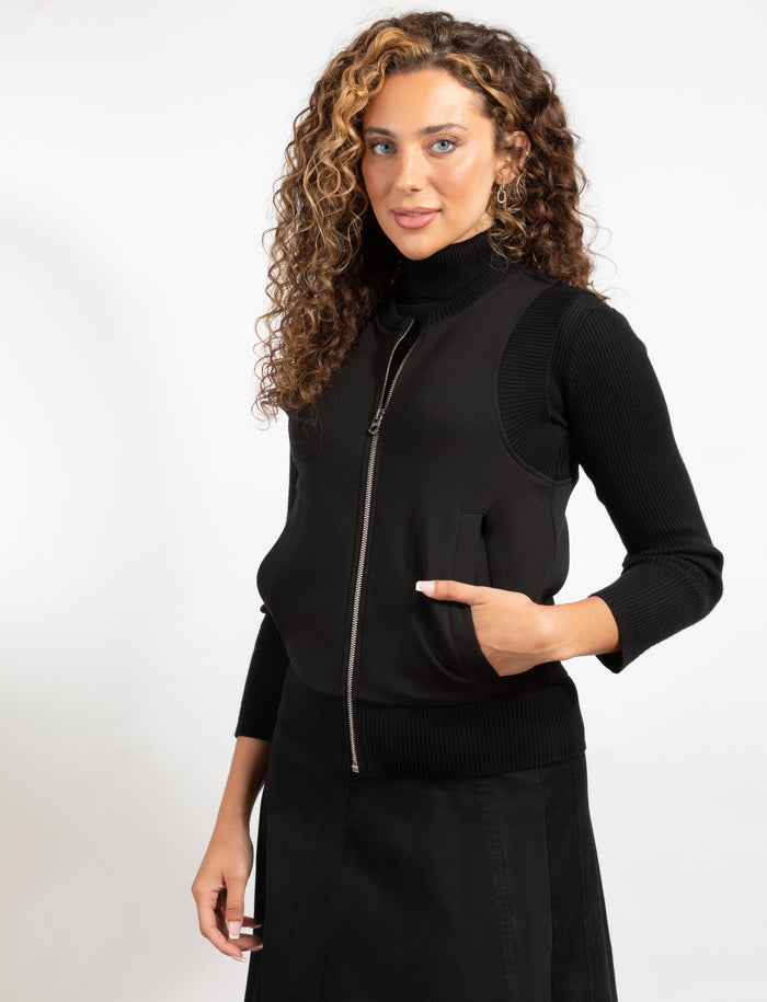 Black zip-front knit vest with stand collar and side pocket detail