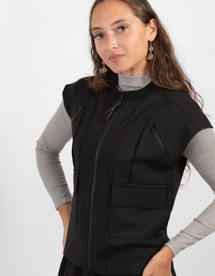 Black zip-front utility vest with ribbed stand collar and front zip pockets.